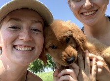 2 girls with a puppy biting