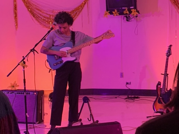 Guitar player on stage with pink background