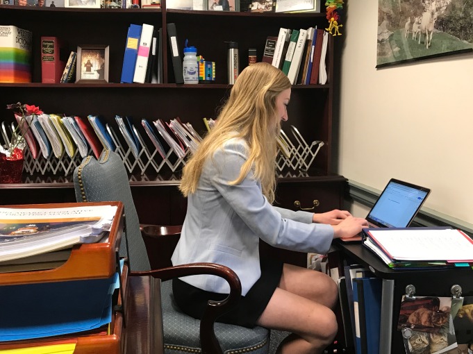 Girl with blond hair typing on laptop