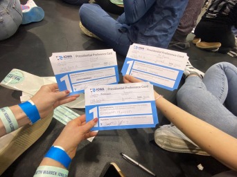Students holding papers together 
