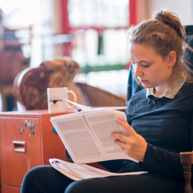 Student studies with mug on cabinet next to her