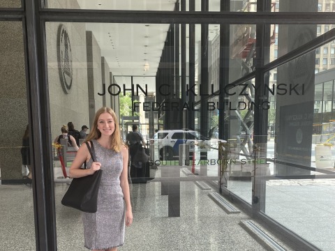 Girl standing in front of building window 