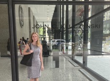 Girl standing in front of building window 