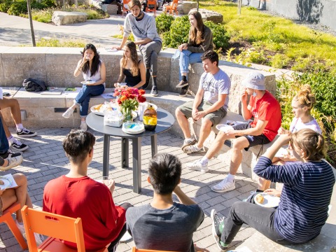 A group of students and their professor enjoy an outdoor class