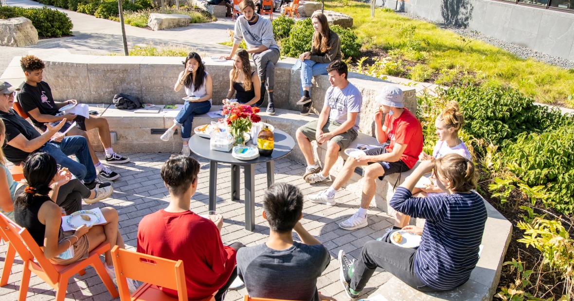 A group of students and their professor enjoy an outdoor class
