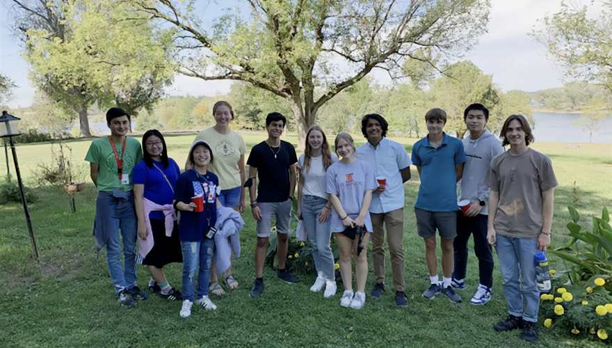 A group of students gathers under a tree